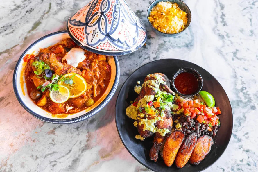 two delicious looking dishes of Latin inspired cuisine including plaintains and black beans at Social Roost in St. Pete