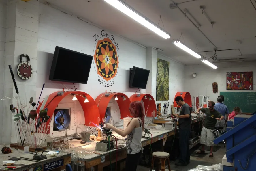 four artists work on creating glass art at zen glass studios in st pete