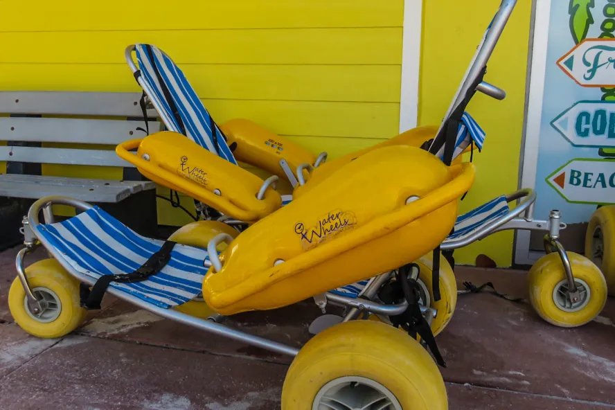 a bright yellow beach wheelchair that is styled like a lounge chair