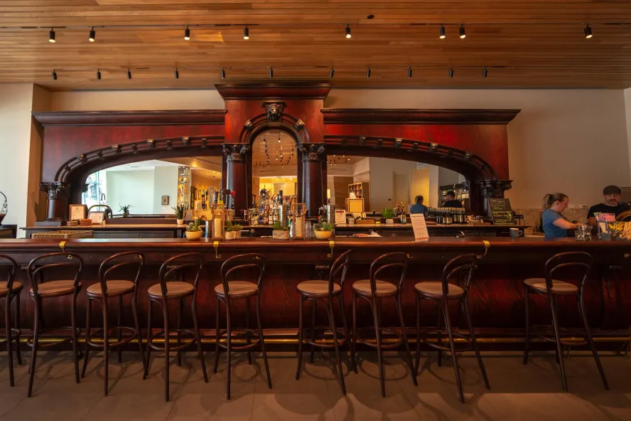 The interior of the Canyon Cafe with a dark-wood bar and metal chairs