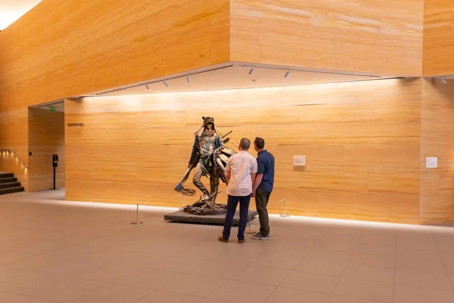 A couple looks at a sculpture in the airy lobby of the James Museum.