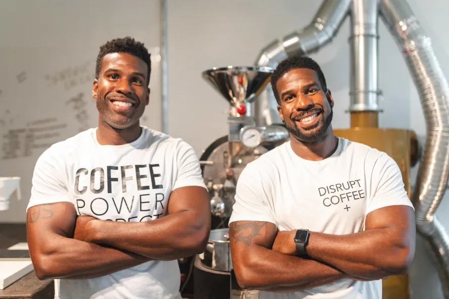 Twin black men wearing white T-shirts with coffee slogans