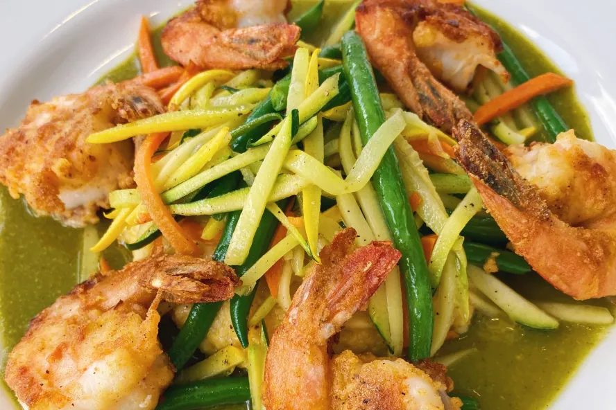 Shrimp and green and yellow veggies on a white plate