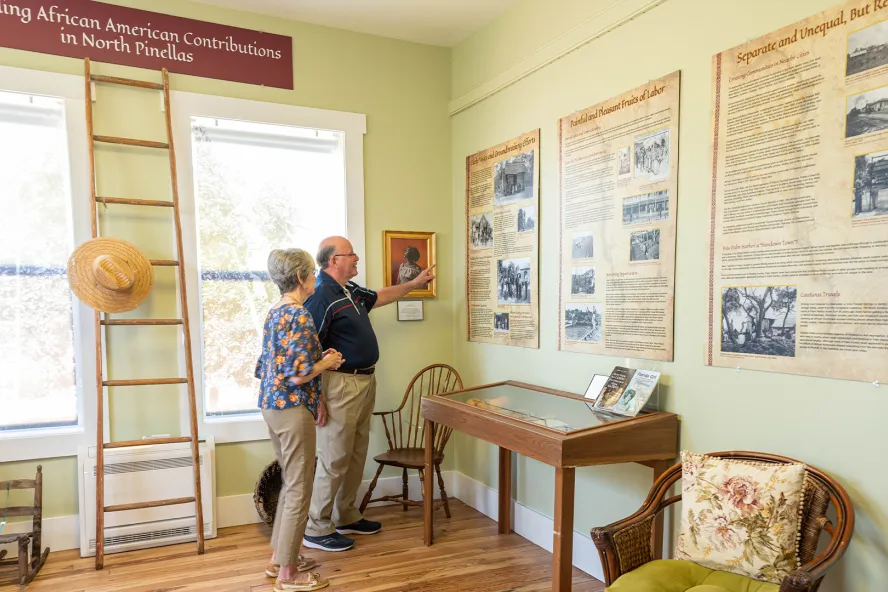 Una pareja de ancianos leyendo carteles en un museo.