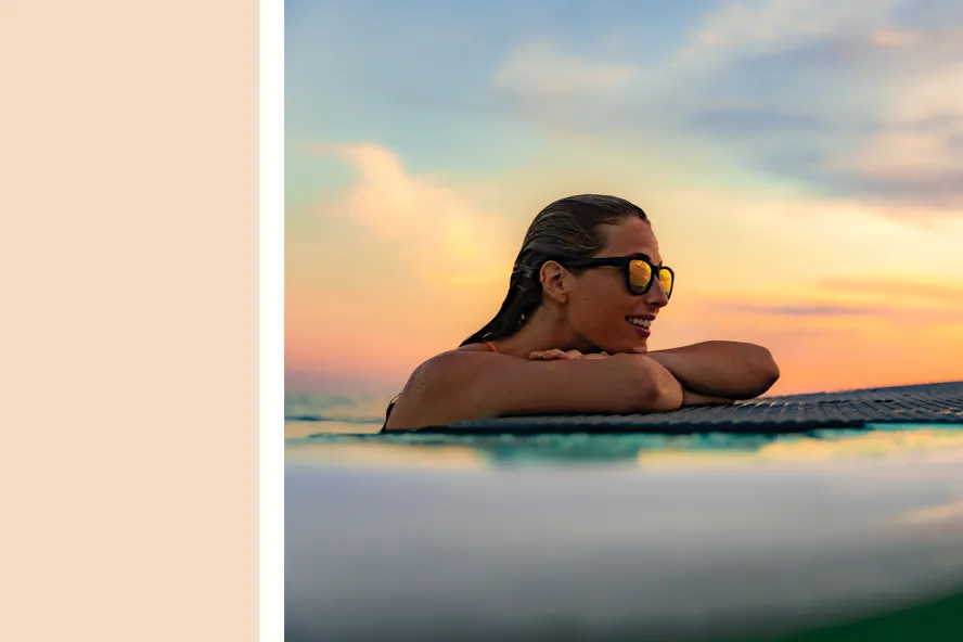 a cream color block next to a lady on a paddleboard watching the sunset
