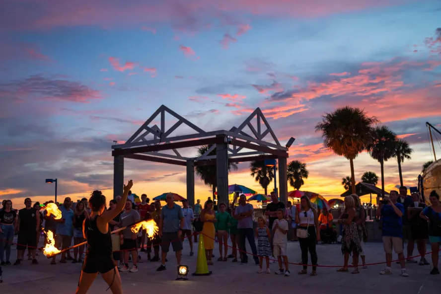 Fire juggler entertains a crowd at sunset