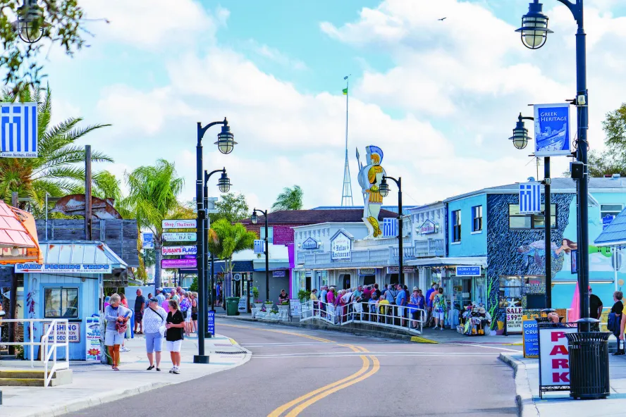 Lots of people line the street in Tarpon Springs, waiting to get into shops and restaurants.