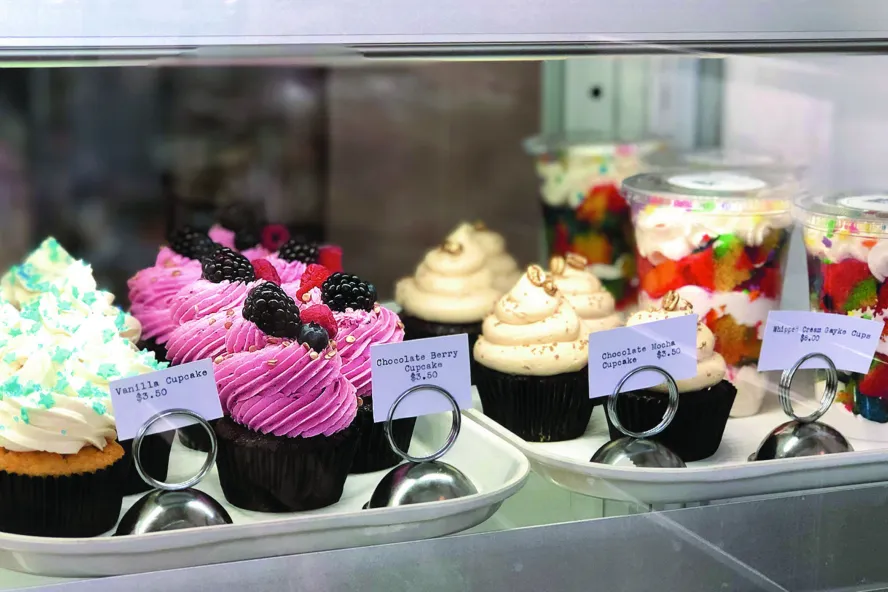 Cupcakes and other desserts in a cooler case.