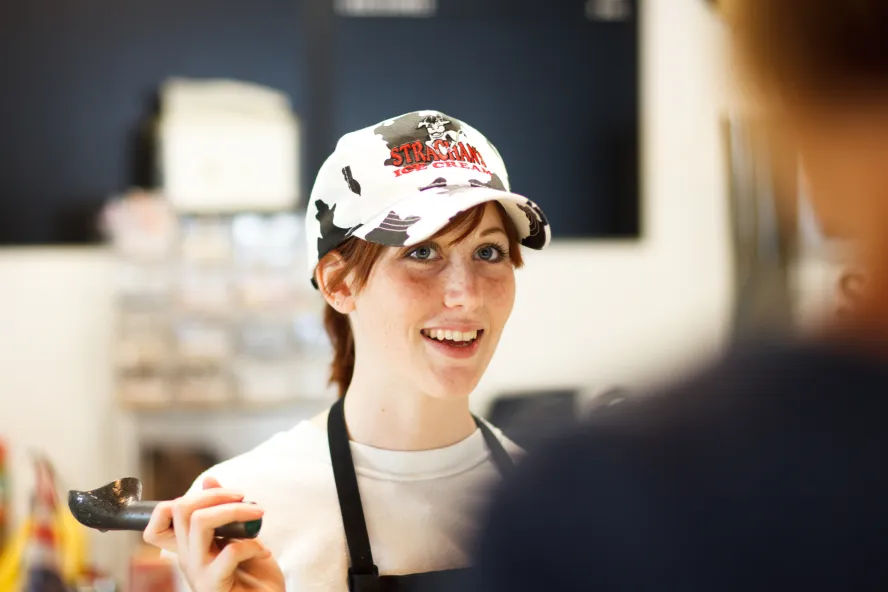 Ice cream shop employee serves a customer