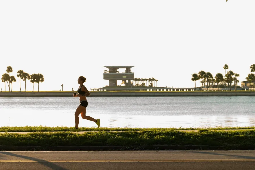 a runner near Tampa Bay with the St. Pete Pier in the background