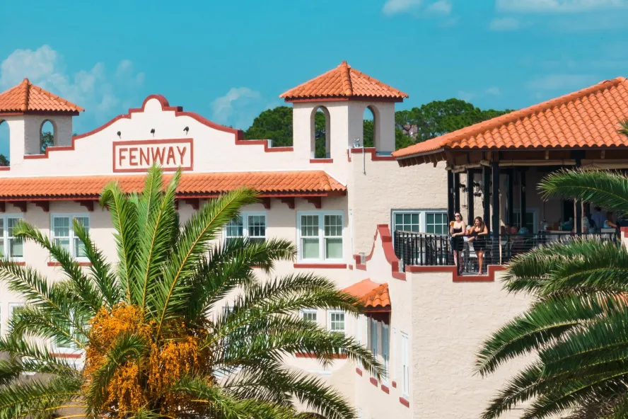 The Fenway Hotel with girls on balcony with palm trees, Dunedin Florida