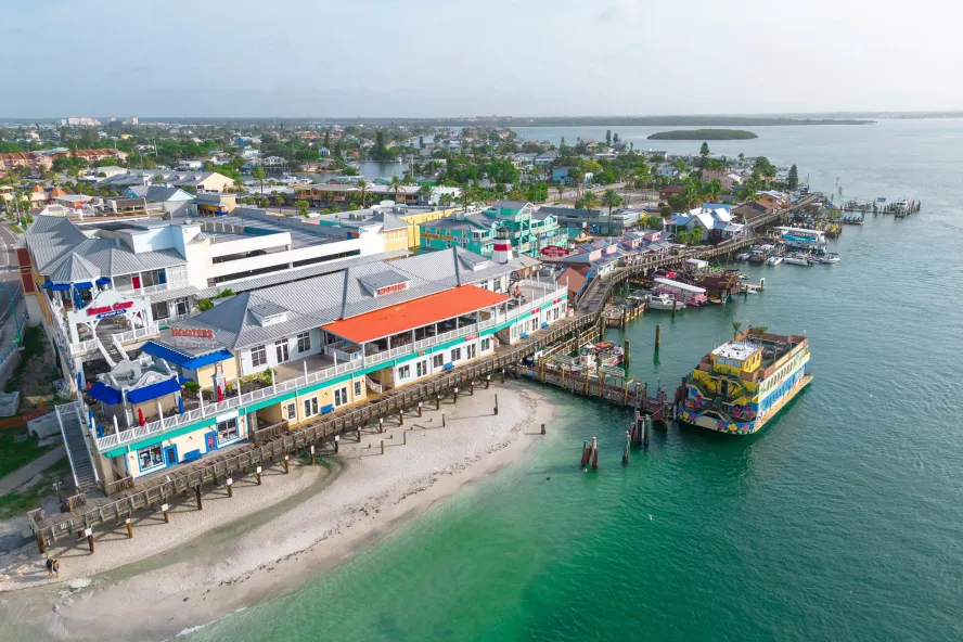 an aerial view of John's Pass Village & Boardwalk, a pier and a large boat