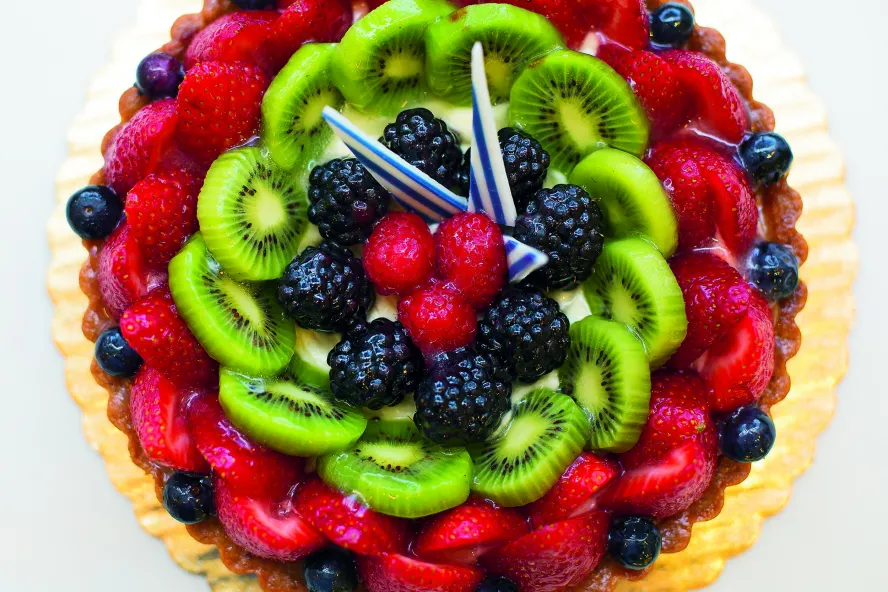 A colorful fruit pie made with berries and kiwi pieces.