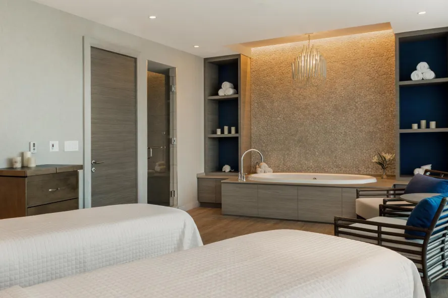 Couples spa treatment room with tub and massage tables