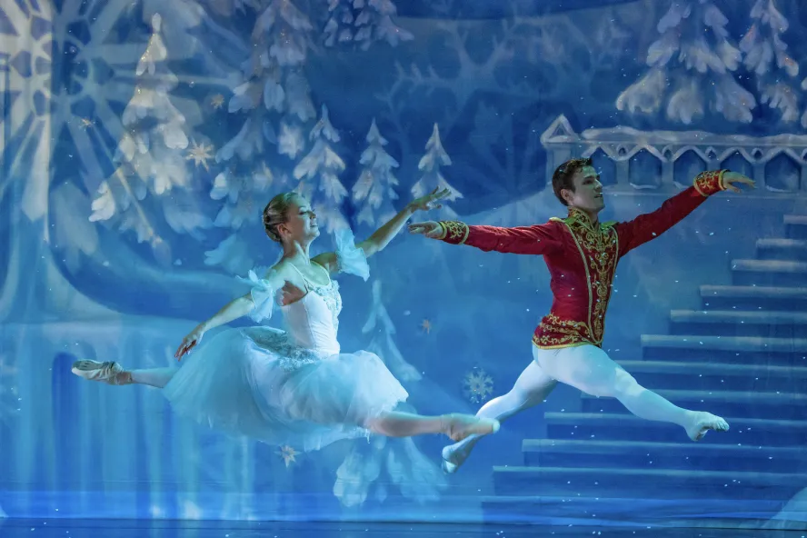 Nutcracker the Christmas Ballet featuring two ballet dancers jumping on stage.