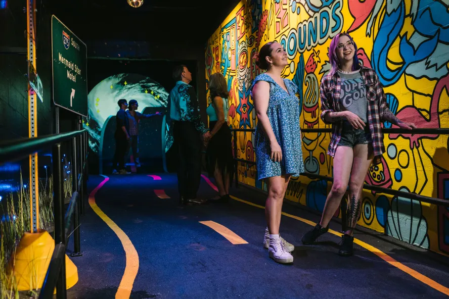 two women walk through a FLoridaRAMA exhibit