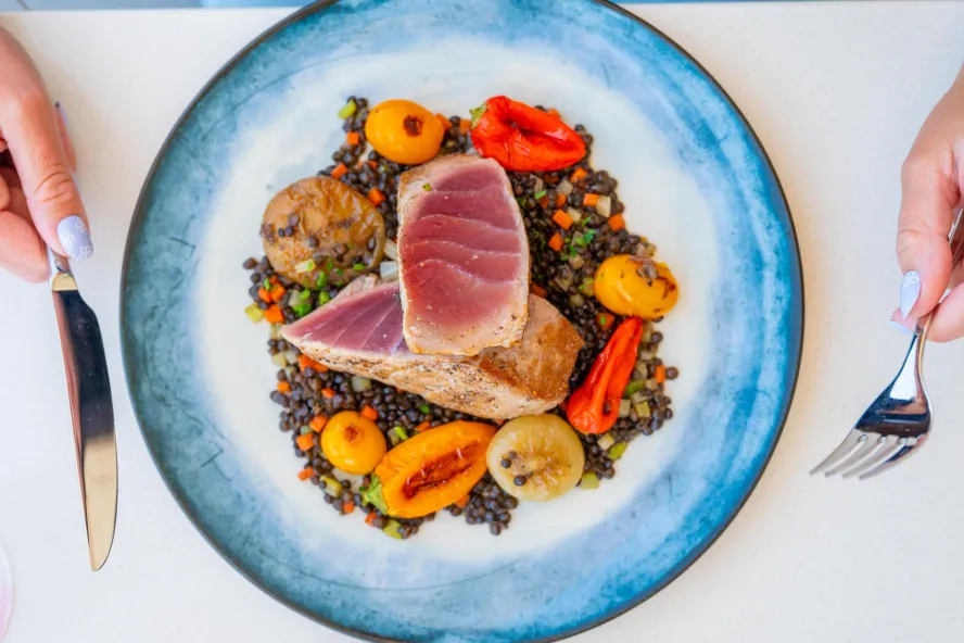 an artfully arrange plate of ahi tuna with veggies and lentils