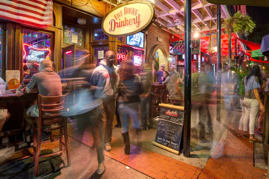 Outdoor tables and customers at Five Buck's Drinkery
