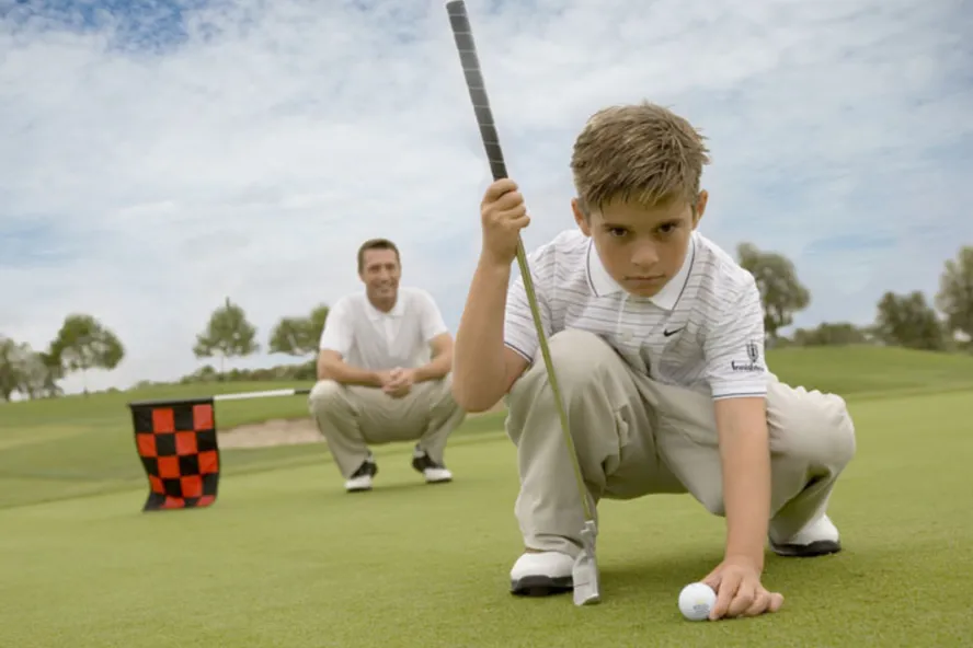 A man and boy play golf together
