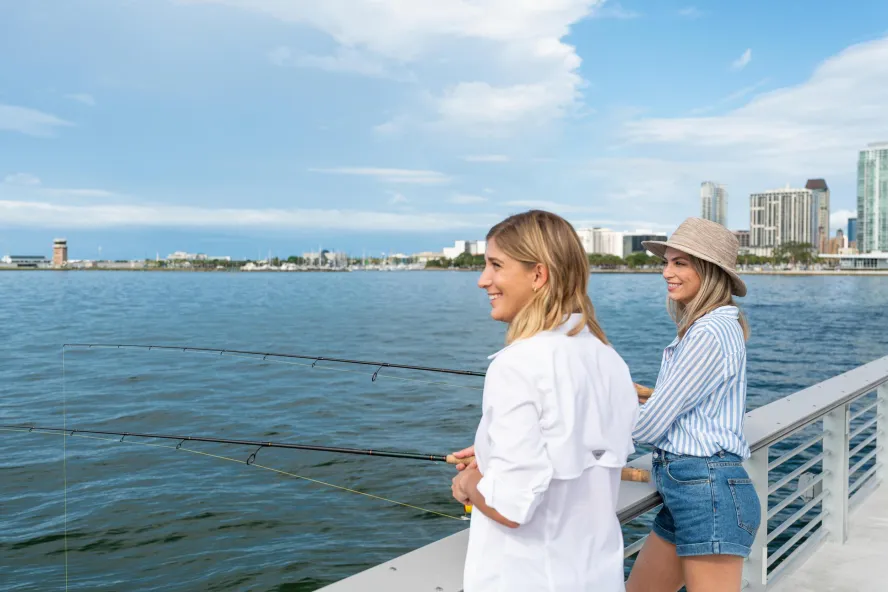Two women fishing off a pier