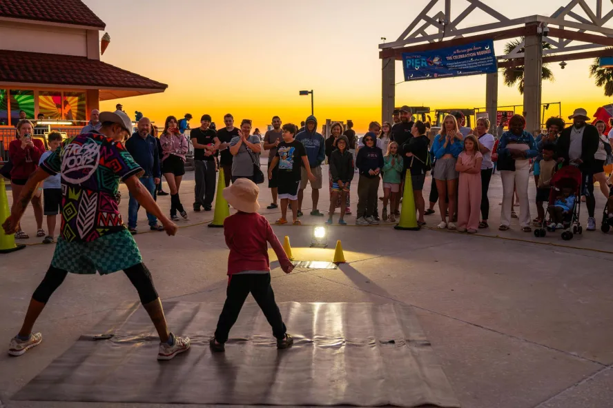 a performer engages with a small child at the sunsets at Pier 60 nightly celebration