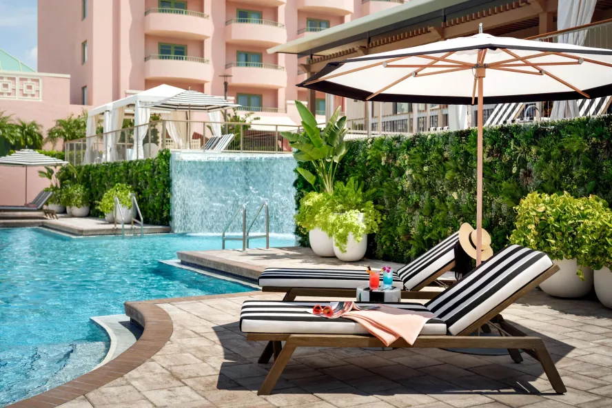 two striped lounge chairs sitting next to Vinoy pool with waterfall feature in background