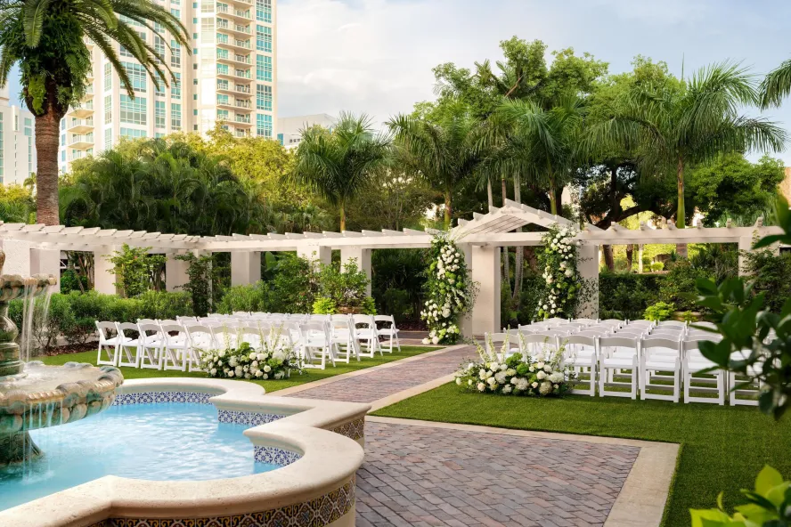 outdoor wedding setup with white chairs on lawn with white flowers at the Vinoy Resort