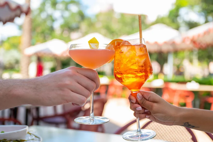 Two people toast with cocktails