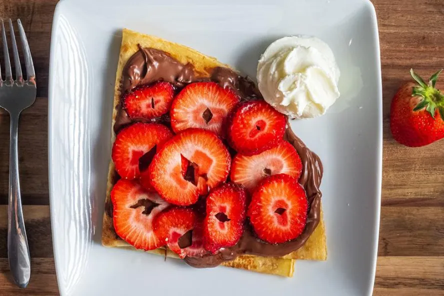 a crepe with nutella and strawberries on top with a dot of whipped cream at Copenhagen Cafe