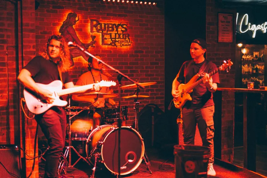 three band members on the stage at Ruby's Elixir club in St. Pete