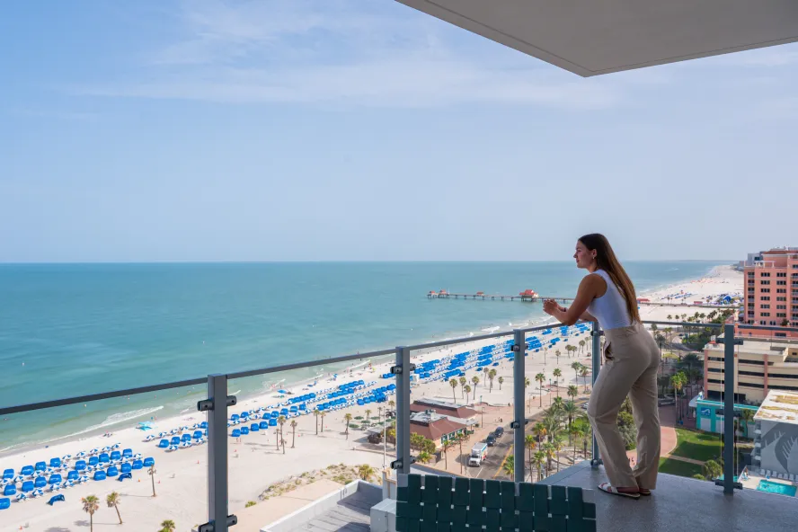 a woman stands on an expansive Gulf-front balcony at Opal Sol resort in Clearwater Beach