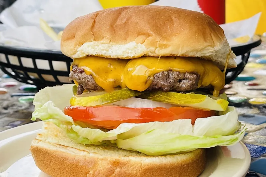 a juicy cheeseburger with tomato, lettuce, onion and pickles at El Cap in St. Pete