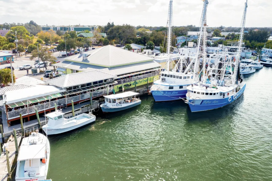 aerial view of Rusty Bellies restaurant on the water in Tarpon Springs; private boats and commercial fishing boats can be seen next to the restaurant