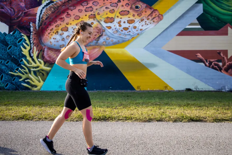 runner going past a colorful fish mural at the St. Petersburg Distance Classic