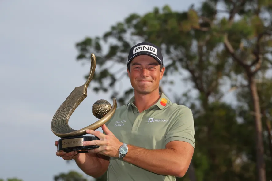 Viktor Hovland holds the winner trophy at PGA Tour's Valspar Championship
