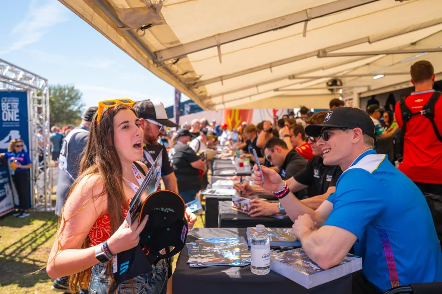 race car drivers sign autographs for fans at the Firestone Grand Prix in St. Petersburg FL