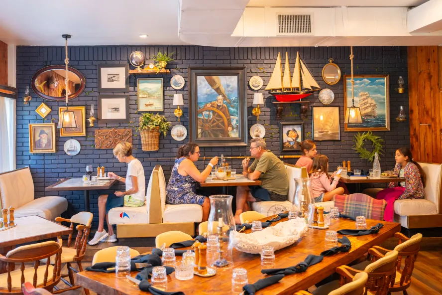 people sitting at three different booths at the nautically decorated restaurant The Helm Seafood & Provisions in St. Pete Beach