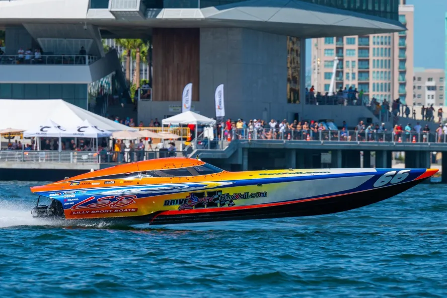 A powerboat speeds past a crowd of fans at the St. Pete Pier on a sunny day in St. Pete, Florida.