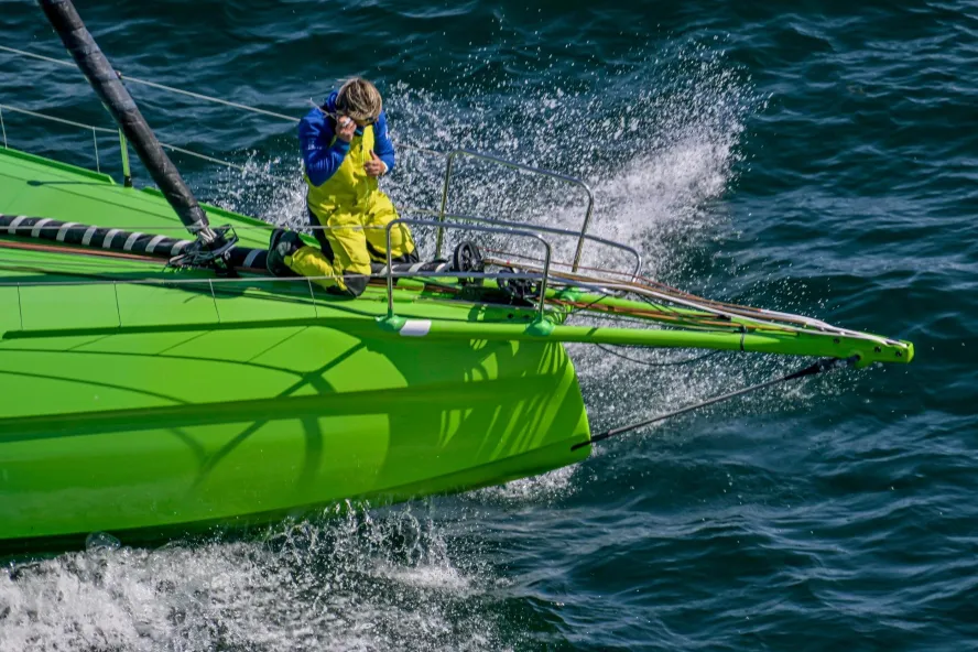 a person at the bow of a bright green sailboat during The Ocean Race, which will come to St. Pete-Clearwater in May 2027