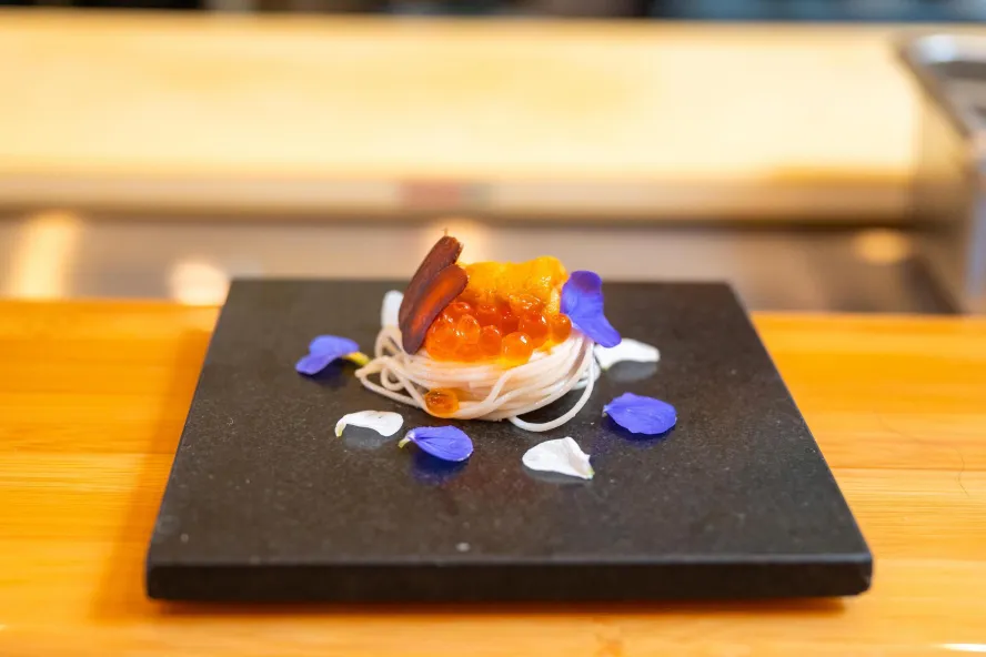 a beautiful plate of sashimi and fish eggs surrounded by flower petals at Sushi Sho Rexley in St. Petersburg FL