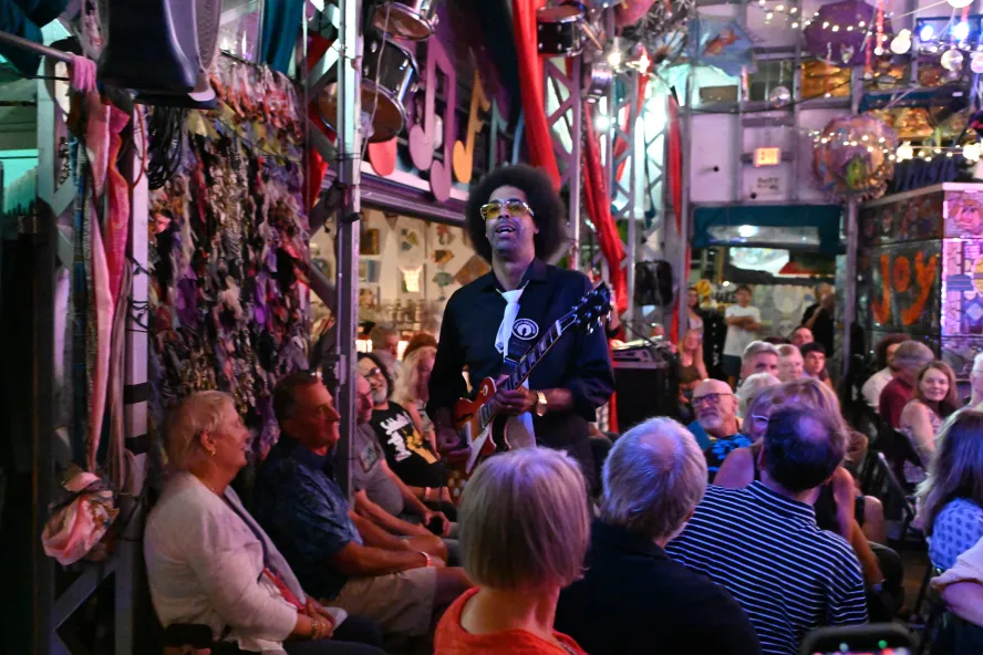 Creative Carnaval festival featuring a man playing guitar in front of a crowd of people.