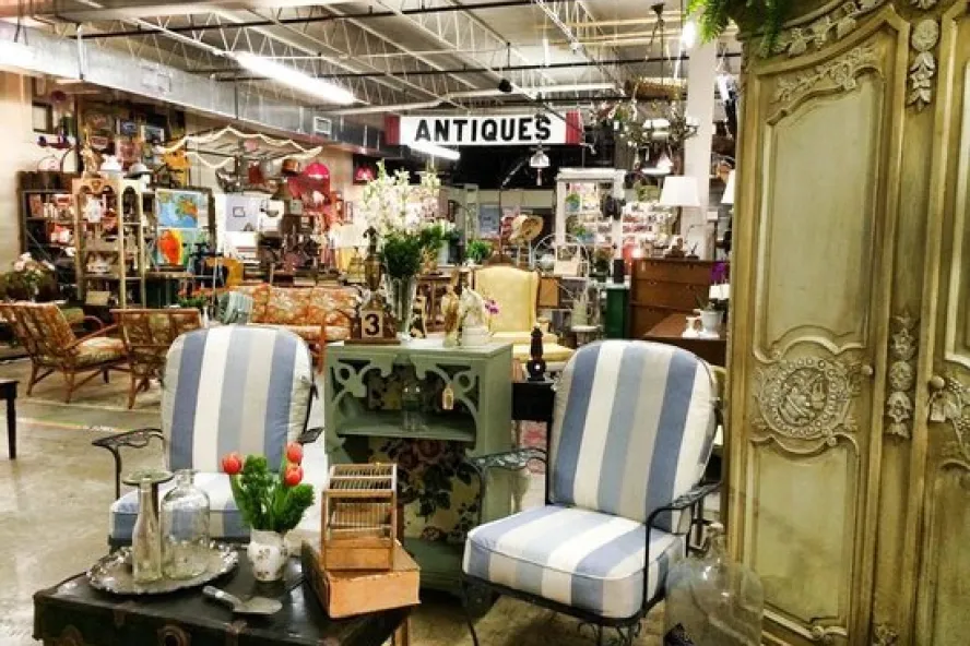 Interior of Vintage Marché filled with antique and vintage furniture, décor and collectibles, including striped chairs and an ornate cabinet.