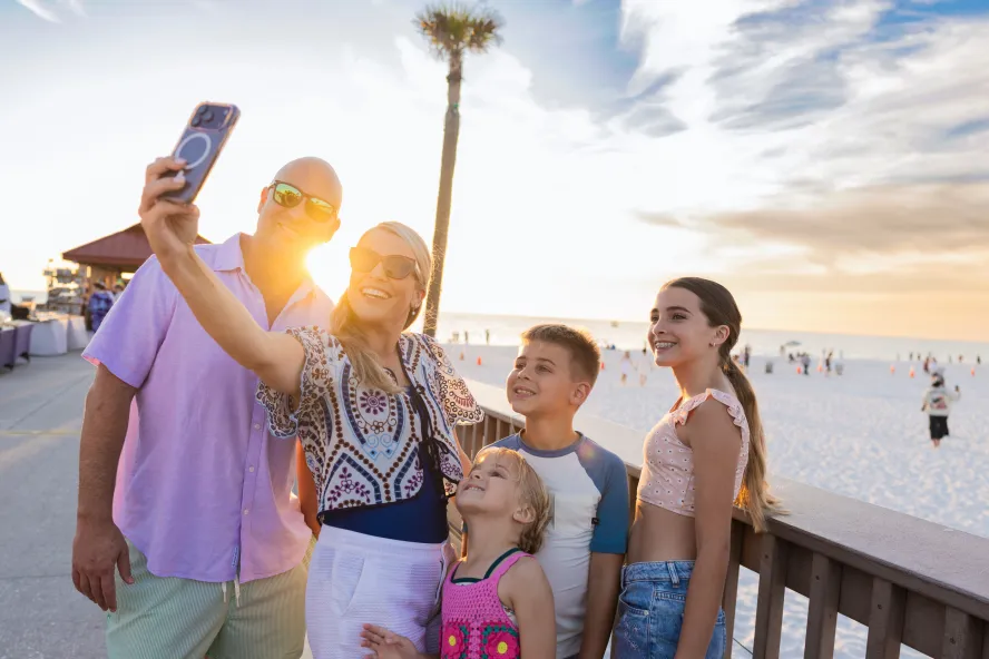 a family takes a selfie at sunset at Pier 60 in Clearwater Beach