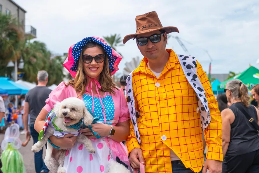 a dog and two people dressed in Toy Story costumes at Halloween on Central in St. Pete