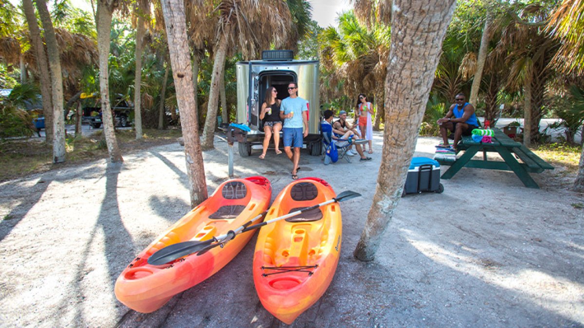 People camping at Fort de Soto park with kayaks in the foreground.