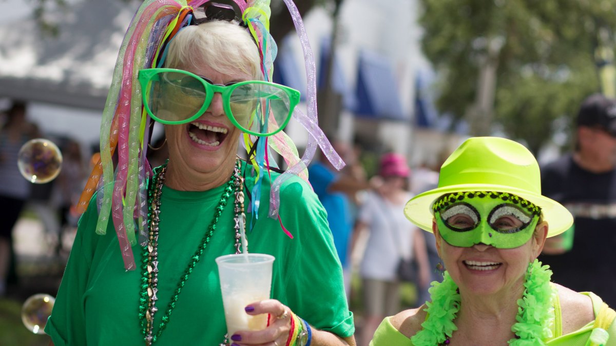 Ladies dressed in green masks and costumes having fun at Geckofest in Gulfport