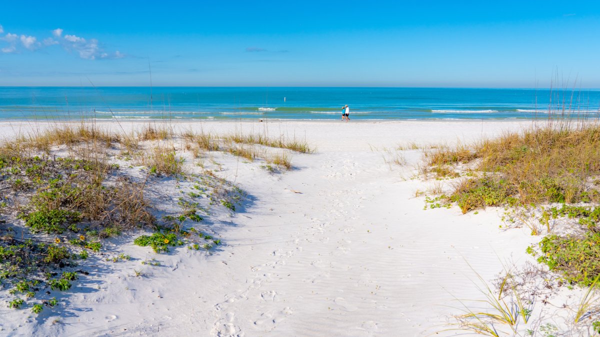 Um casal caminhando nas areias brancas de Redington Shores