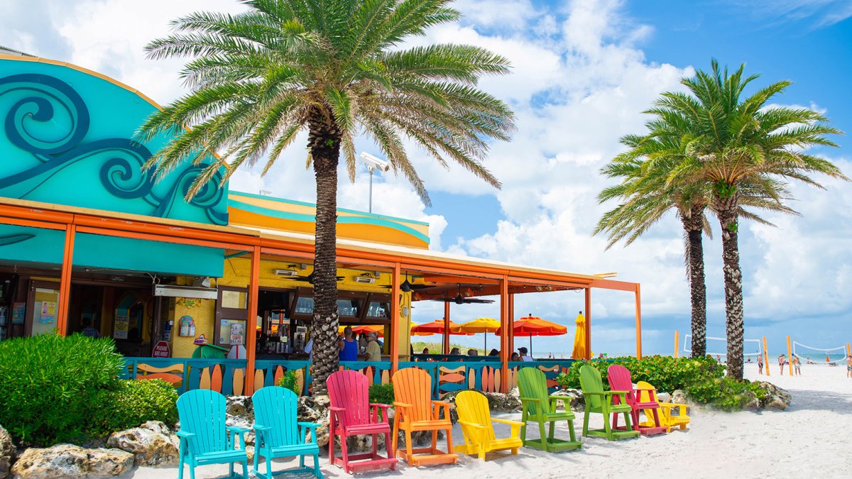 Bunte Adirondack-Stühle am Strand vor Frenchy's Rockaway Grill