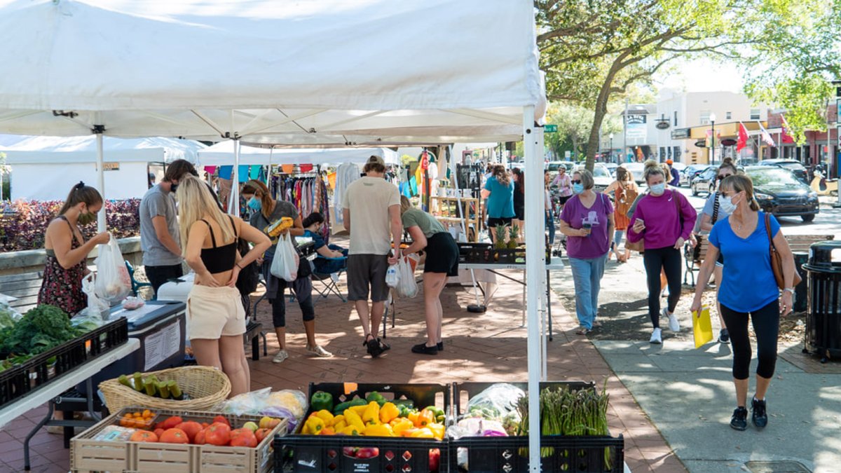 La gente busca productos en un puesto en el mercado de Safety Harbor en Main.