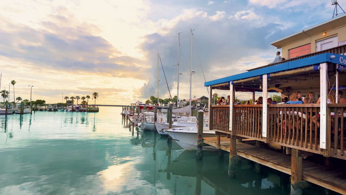 The soft light of sunset is seen over the water and dock at the Dunedin Marina